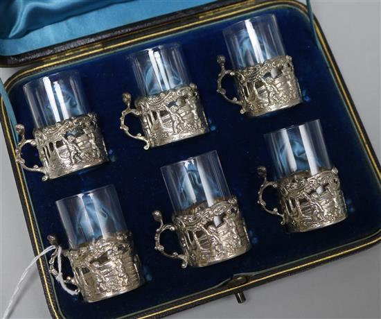 A late Victorian cased set of six repousse silver cup holders by William Comyns, Birmingham, 1891, with glass inserts.